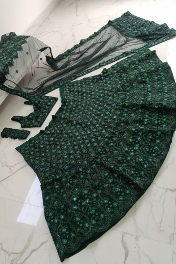 Green embroidered fabric on a white marble surface