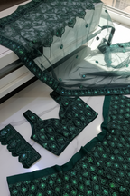 Green lace tablecloth with intricate patterns on a white surface